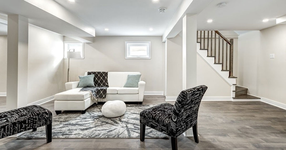 Finished basement converted to a living room with recessed lighting, laminate flooring, and staircase