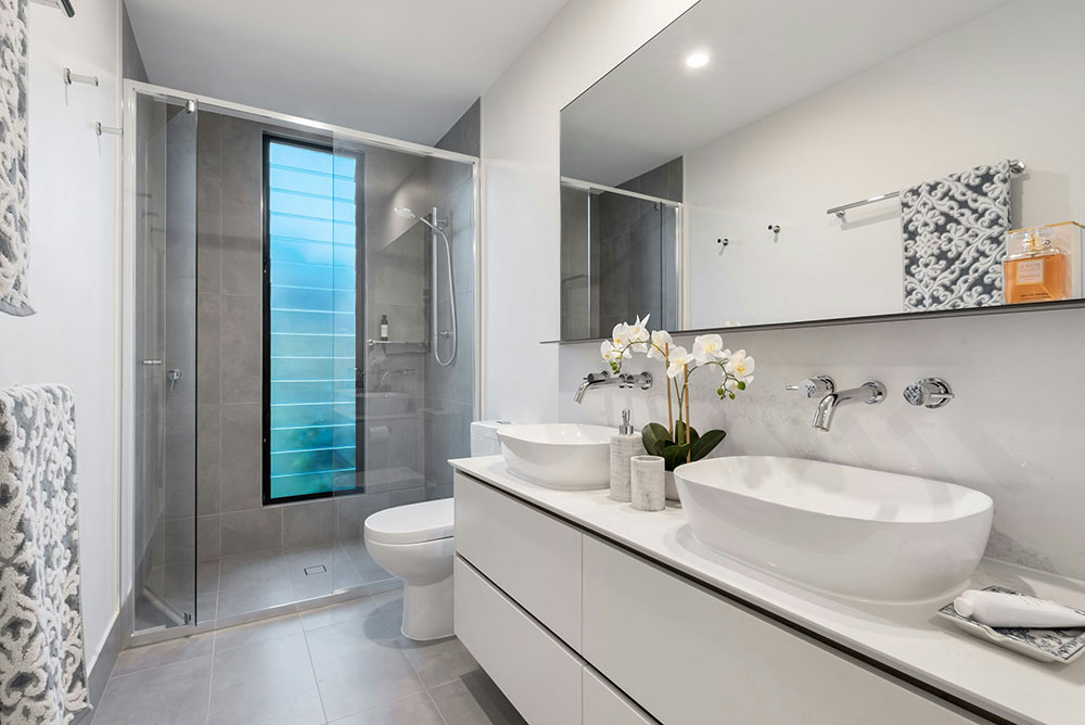 Remodeled bathroom with walk-in tile shower and double vanity