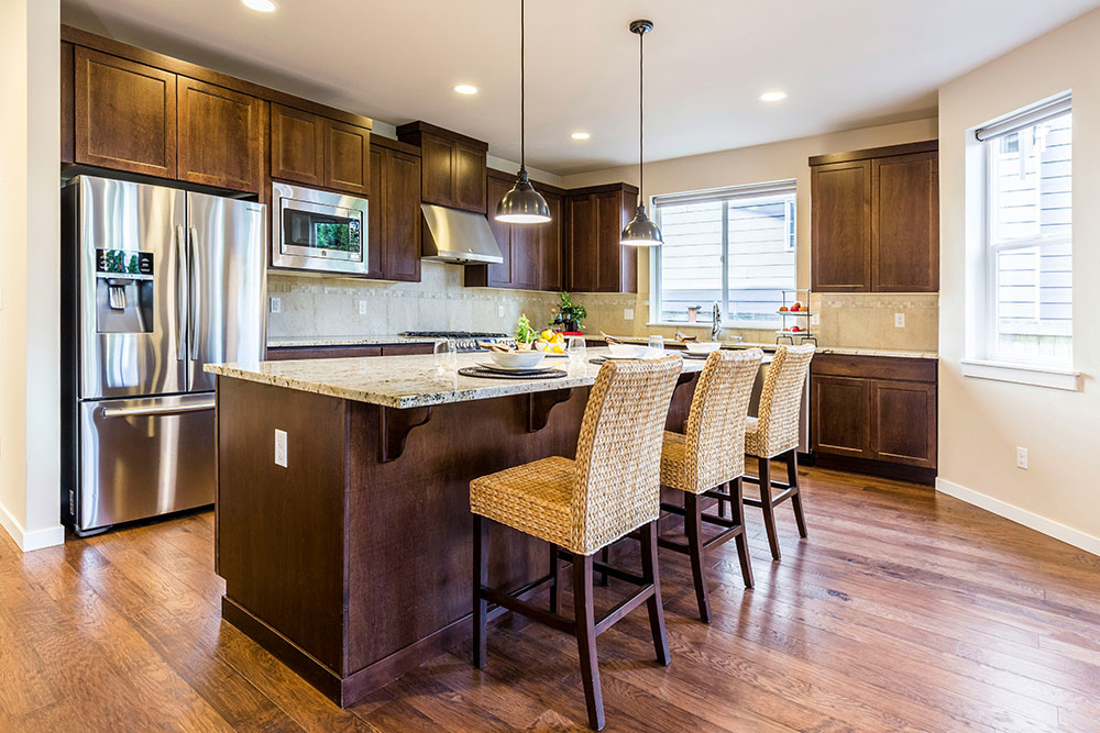 Renovated kitchen with brown cabinets and quartz countertops