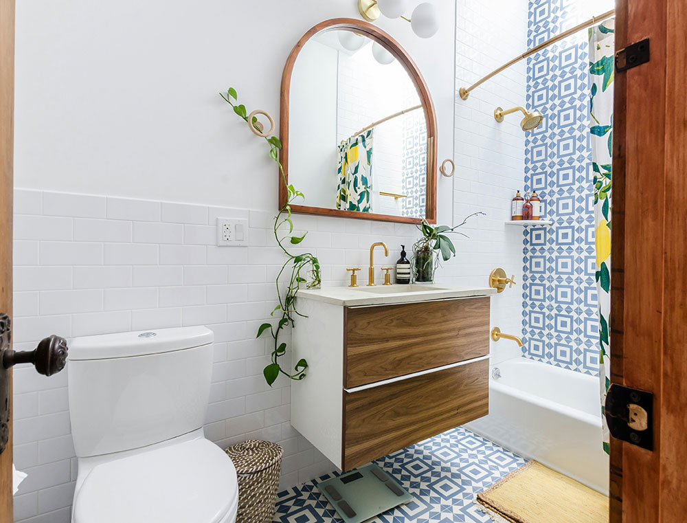 Small remodeled bathroom with a tub-shower combo, a floating wood vanity, white subway tile, and patterned blue floor tile